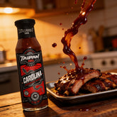 TAIPAN BBQ Carolina ultra hot Carolina Reaper BBQ sauce 250ml — action shot, sauce splashing over ribs mid-air