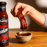 TAIPAN BBQ Carolina ultra hot Carolina Reaper BBQ sauce 250ml — in-use shot, dipping a rib into the sauce