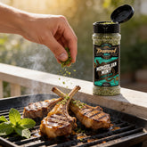 TAIPAN BBQ Mongolian Mint lamb BBQ rub 125g — in-use shot, rubbing mint seasoning onto lamb chops on the grill