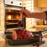 TAIPAN BBQ Rosella Royale Sunday Glaze native rosella BBQ glaze 250ml — in-use shot, brushing glaze onto ham in the oven
