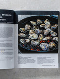 The Outdoor Cook by America's Test Kitchen paperback cookbook — grilled oysters and shellfish recipe spread