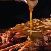 Tillman's Barbecue Florida Gold mustard sauce poured over pulled pork, close-up lifestyle shot