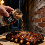 Uncle Mungo's Smoked Maple Garlic 300g smoked maple garlic dry rub — shaking smoked maple garlic rub over glazed pork ribs