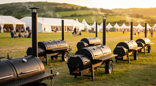 A row of offset smoker trailers at a generic Australian BBQ festival at golden hour