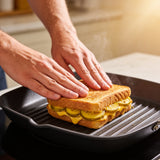 Hands pressing a grilled cheese and pickle toastie with ACIDE Bread and Butter Zucchini Pickles