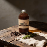 THE FEEDLOT Barnyard Brew Espresso BBQ Sauce - beauty shot on rustic wood with coffee beans