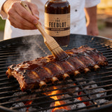 THE FEEDLOT Barnyard Brew Espresso BBQ Sauce - being brushed onto beef ribs on the grill