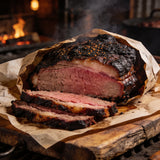 Whole smoked brisket sliced open on butcher paper showing a deep pink smoke ring