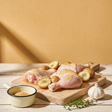 Outlaw Barbecue Gold Rush 280g garlic butter BBQ rub — raw chicken and baby potatoes seasoned and ready to cook
