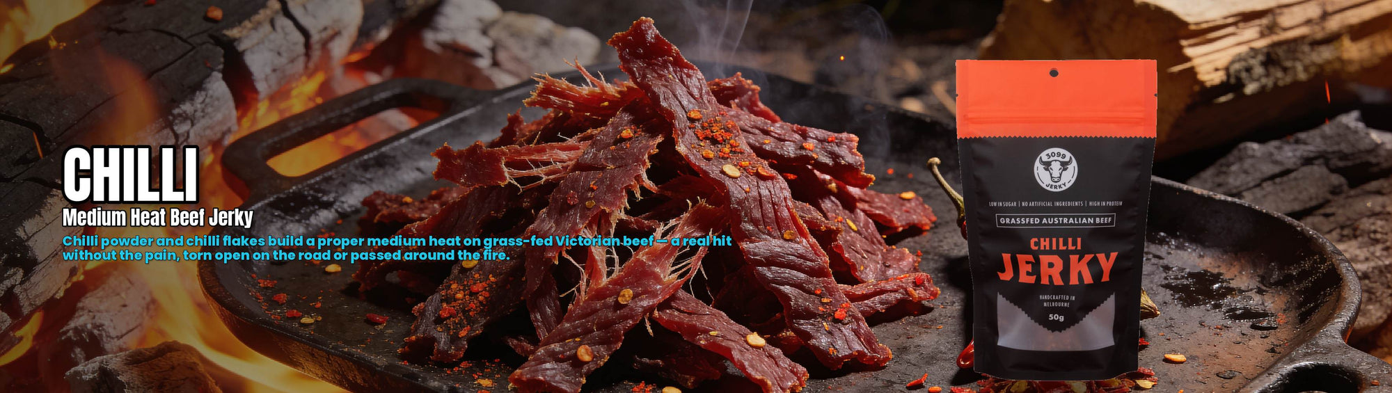 3099 Jerky Chilli Beef Jerky 50g — torn chilli beef jerky over campfire coals with the pouch