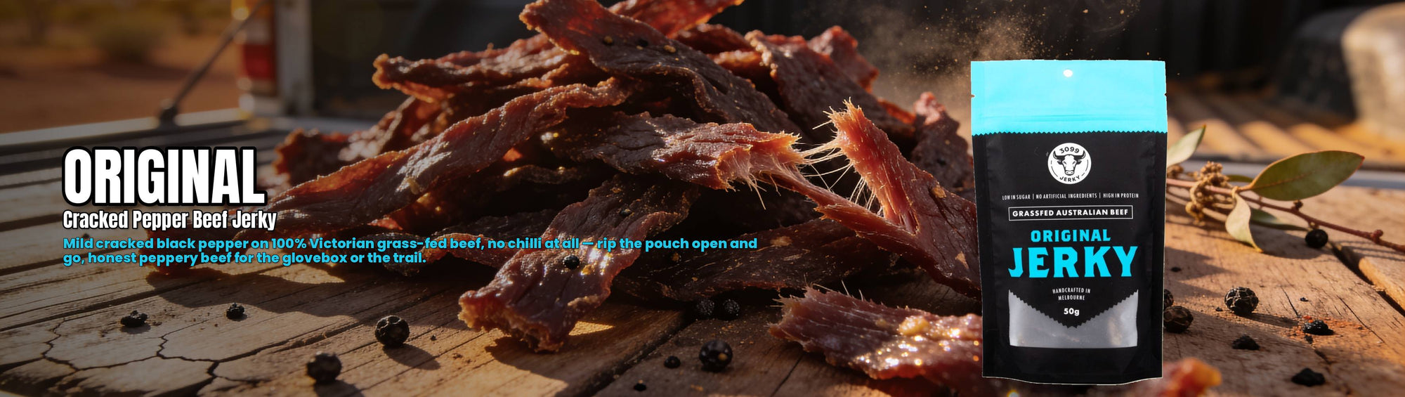 3099 Jerky Original Beef Jerky 50g — torn peppered beef jerky on a ute tailgate with the pouch