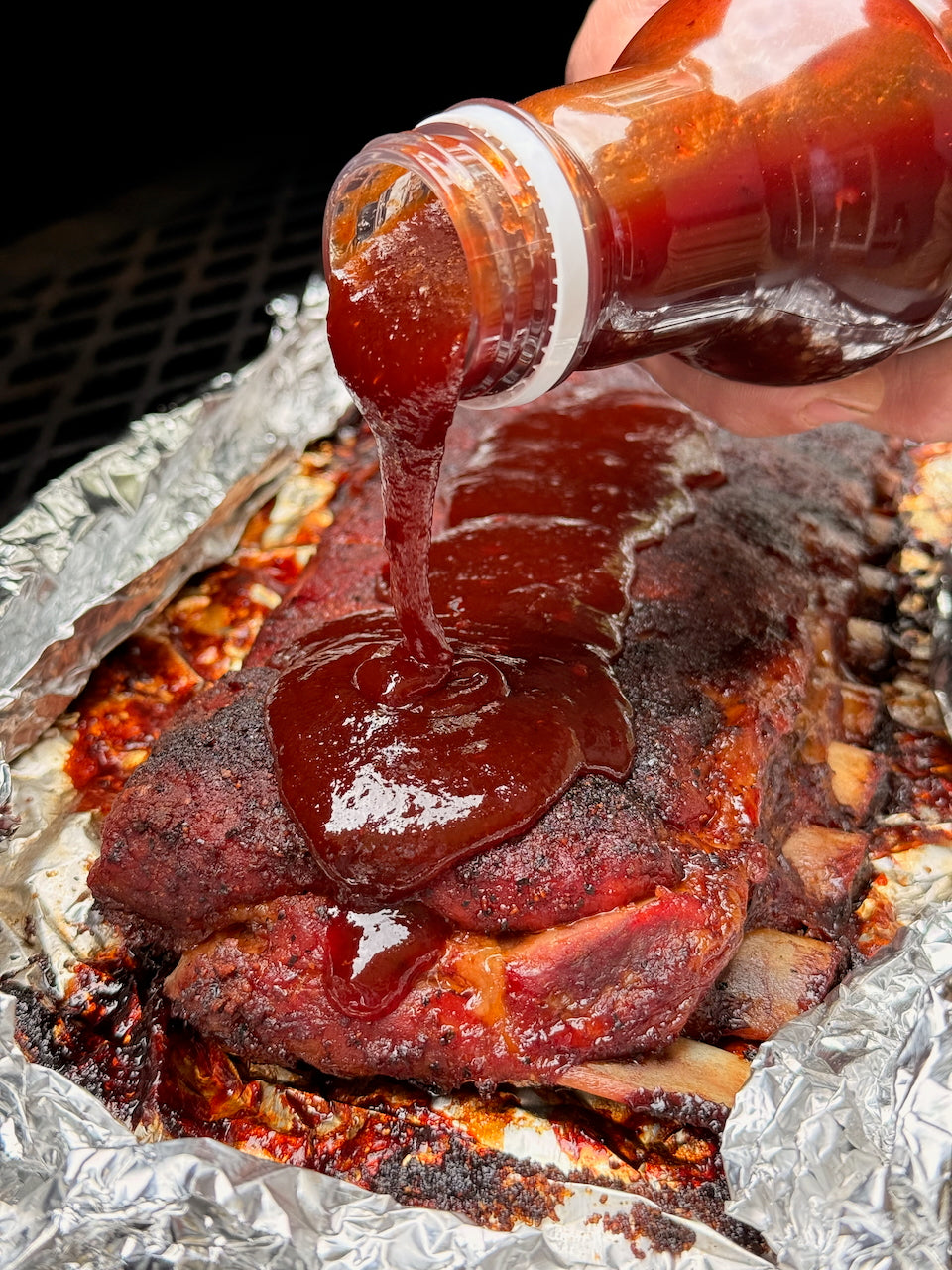 Hardcore Carnivore Saucesome BBQ sauce being poured
