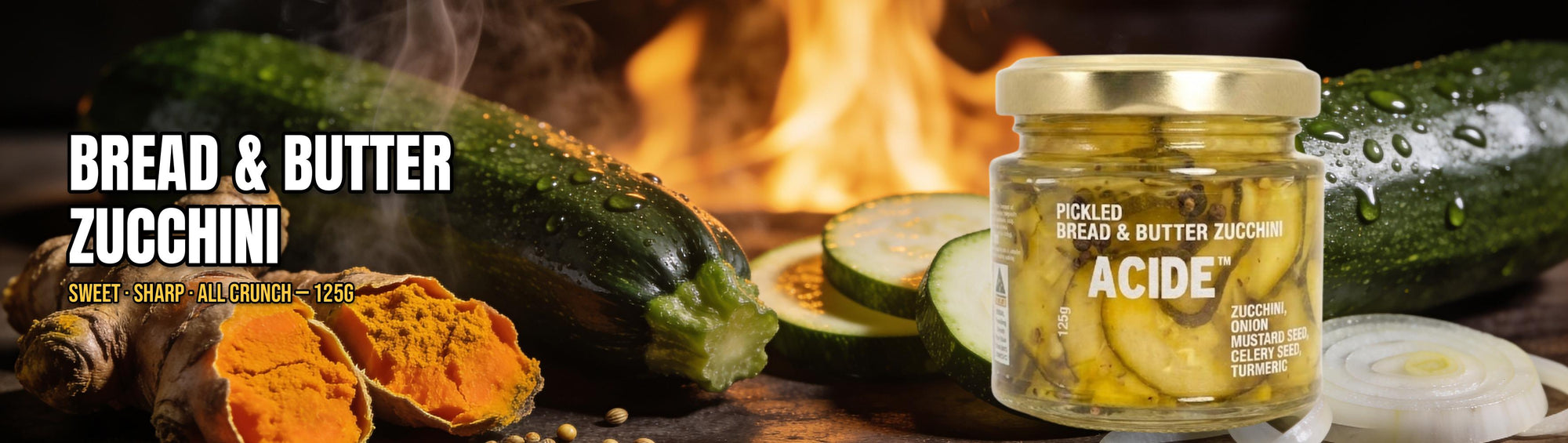 ACIDE Bread and Butter Pickles 125g banner, jar with fresh zucchini, turmeric and mustard seed over an open fire