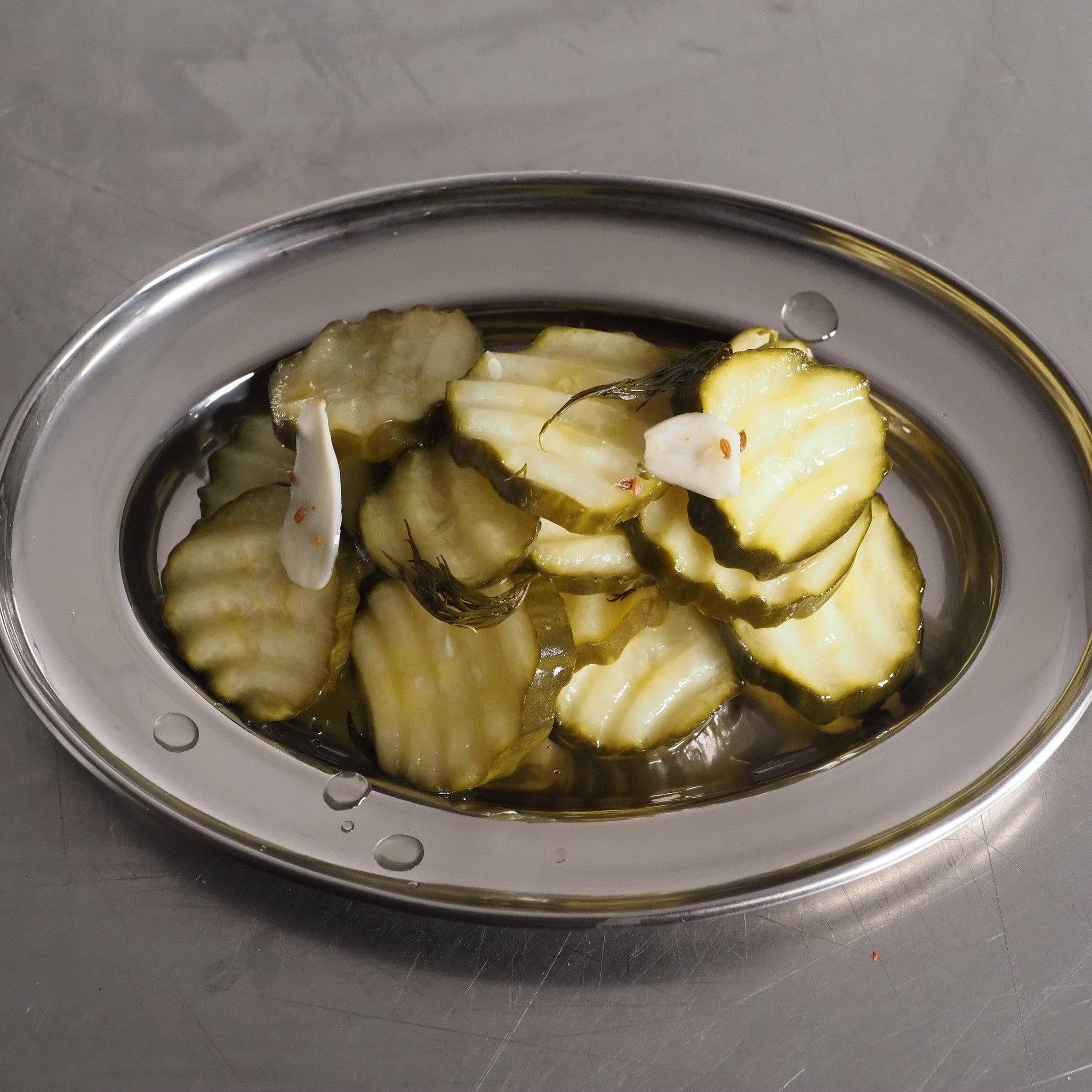 ACIDE Dill Cucumber Chips crinkle-cut dill pickles served on a board