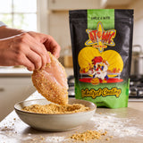 Atomic Chicken Chicken Schnitzel Herb & Garlic Coating 450g — hands crumbing a raw schnitzel at the kitchen bench