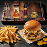 The Rub Hub Bangin Burger Box - all four products on a charred timber board with a double smash burger and seasoned hot chips