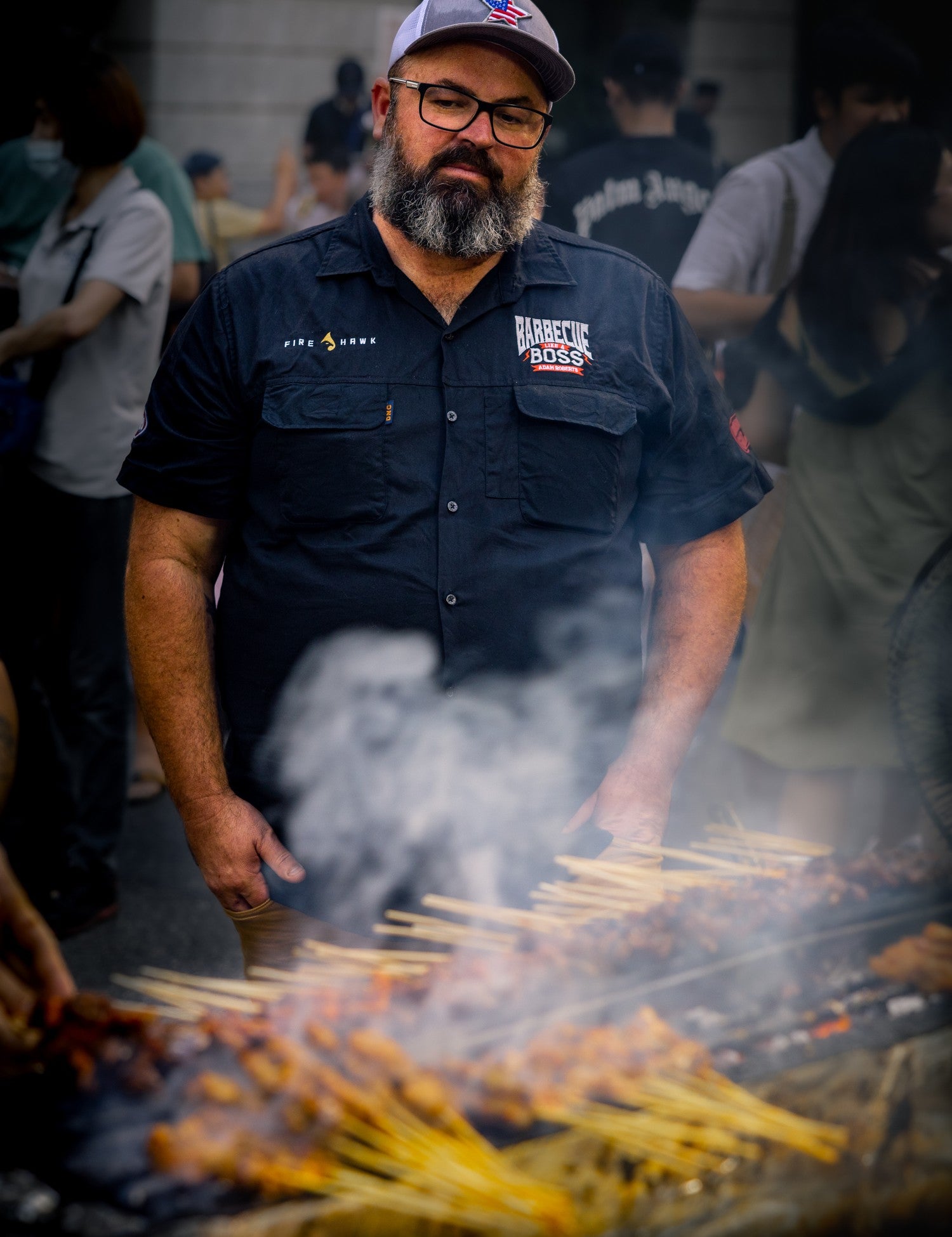 Barbecue Fusion by Adam Roberts hardback cookbook — author Adam Roberts at a smoking skewer grill