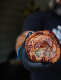 Barbecue Like a Boss by Adam Roberts hardback cookbook — two halves of a rolled pork belly with crackling