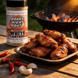 Boars Night Out Spicy White Lightning shaker beside a platter of glazed hot wings with fresh chilli and garlic