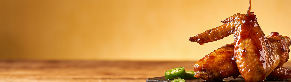 Butchers Axe Sweet Heat BBQ Sauce — cinematic banner, bbq sauce composited into a lifestyle BBQ scene