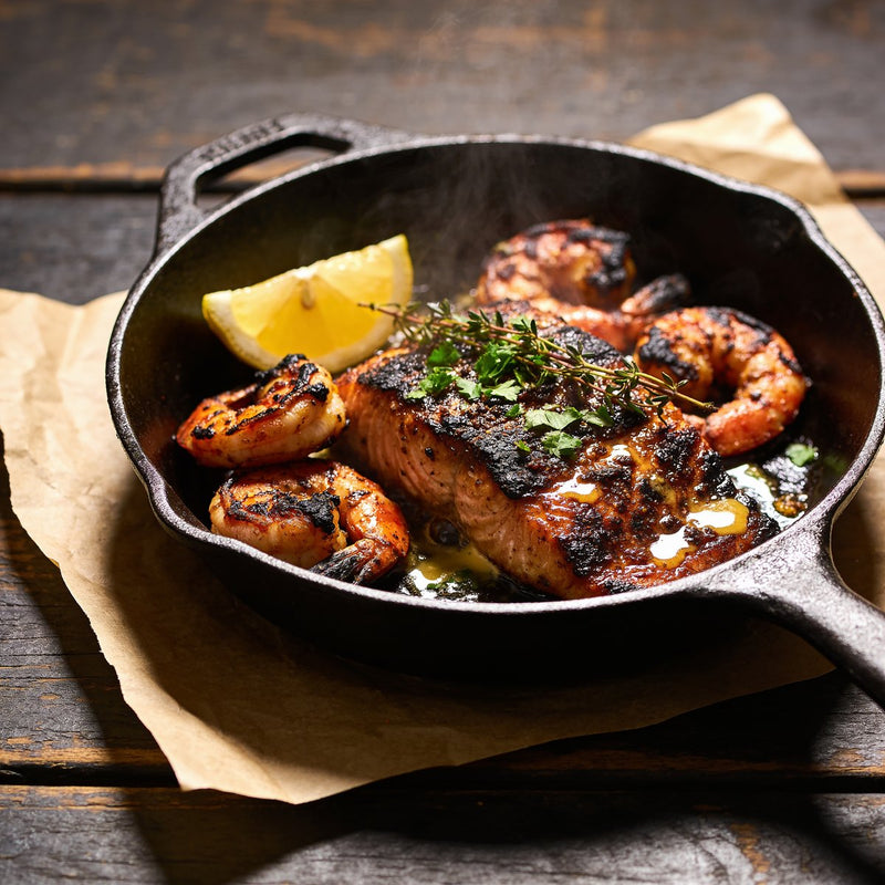 Blackened Cajun-style fish and prawns fresh off a cast-iron skillet — Cajun flavour on The Rub Hub lifestyle photo