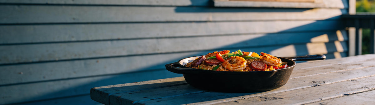Skillet of prawn and sausage jambalaya on a porch table, spiced with Carolina Smoke Creole Seasoning