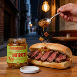 Chuck Hughes Mild Antipasto spooned onto a steak sandwich, open jar on the table