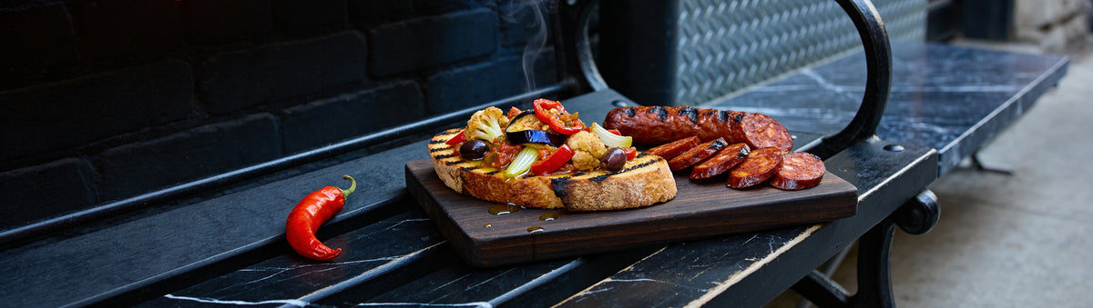Chuck Hughes Spicy Antipasto — grilled sourdough with spicy antipasto and chorizo on a marble bench