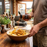 Coast n Smoke South West rub — home cook tossing potato wedges with the smoky rub in a bowl