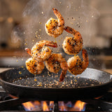 Coast n Smoke SPG salt pepper garlic — chargrilled prawns caught mid-toss above the grill, glossy and juicy