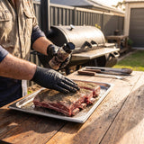 Coast n Smoke T-Rub Umami seasoning — pitmaster patting the dark umami rub onto raw beef short ribs