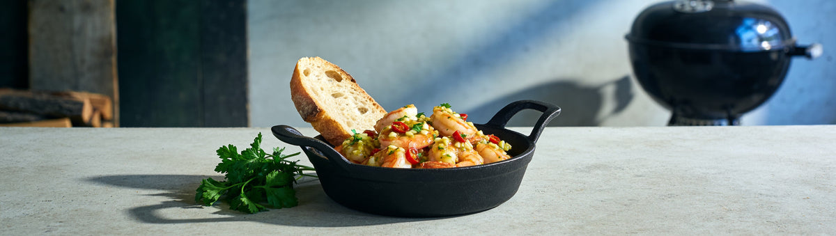 Garlic prawns in Cobra Chilli Garlic Habanero Chilli Sauce butter with crusty bread on a kitchen bench