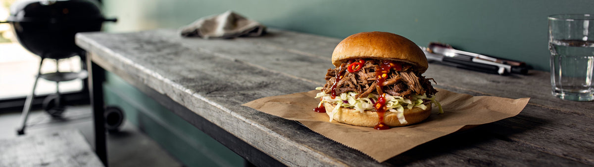 Pulled pork burger with slaw and Cobra Chilli Habanero Chilli Sauce on butcher paper