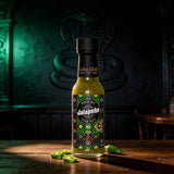 Cobra Chilli Jalapeño Pepper Sauce Mild 150ml hot sauce — styled hero shot in Cobra Chilli's gothic-western brand setting