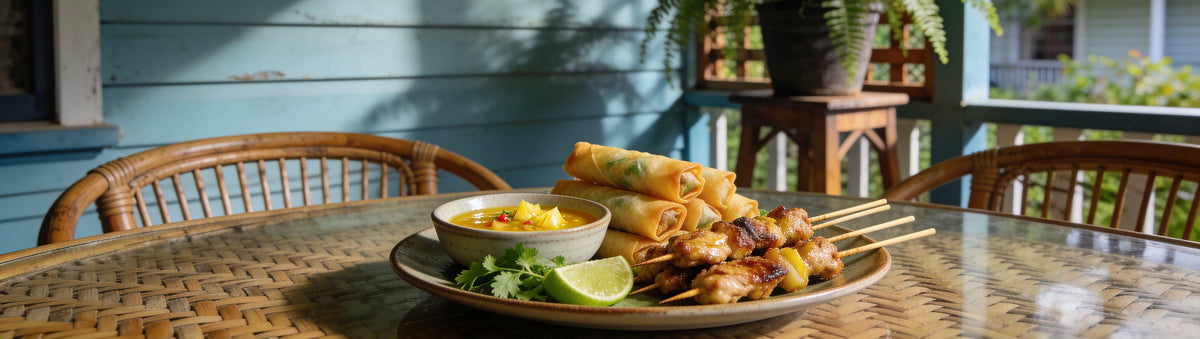 Spring rolls and chicken satay with Cobra Chilli Tropical Zing Chilli Sauce for dipping on a rattan table