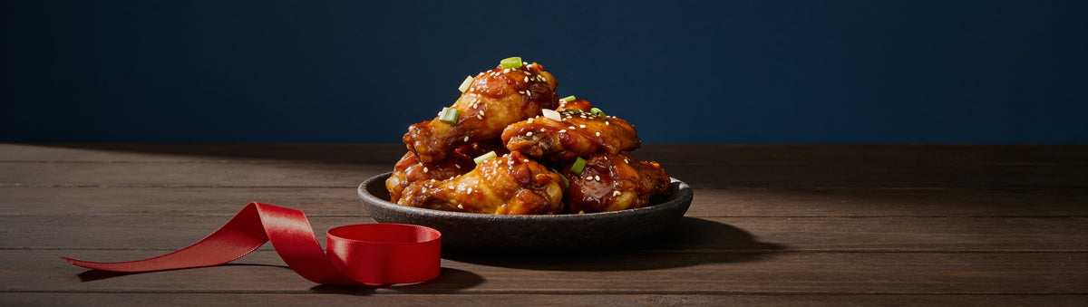 The Smuggler's Gift Crate banner — sticky glazed chicken wings with a red ribbon
