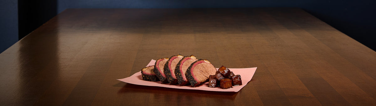 The Kingpin banner — sliced brisket with black bark and burnt ends on butcher paper