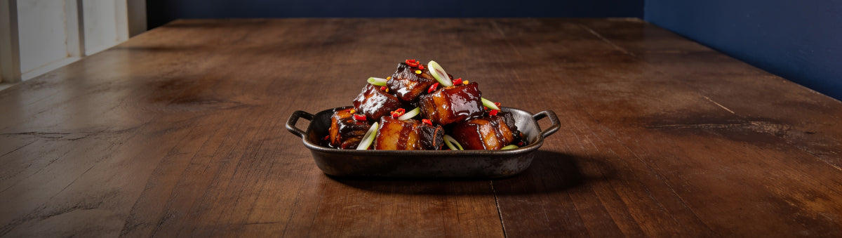 The Quartermaster banner — tray of hot honey pork belly burnt ends with chilli flakes