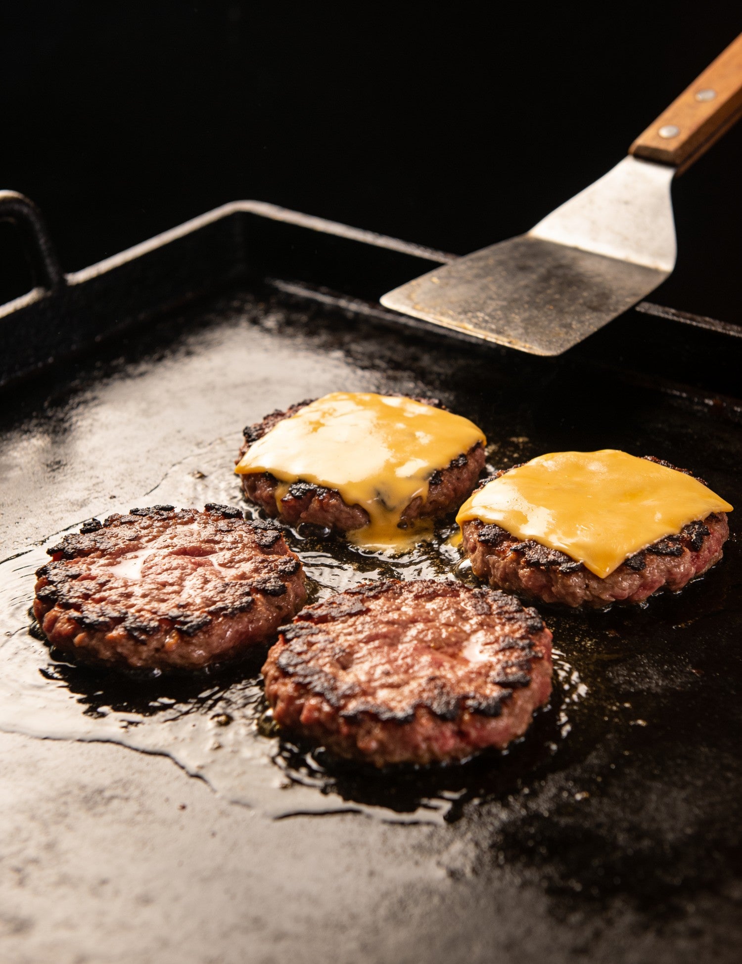 The Stowaway lifestyle — smash patties with lacy crispy edges on a hot flat plate