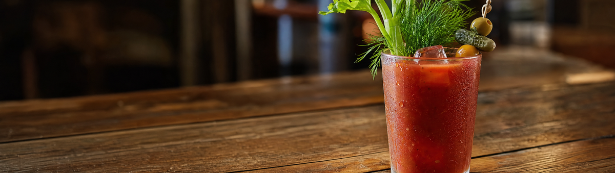 A garnished Bloody Mary cocktail with fresh dill on a rustic brunch table