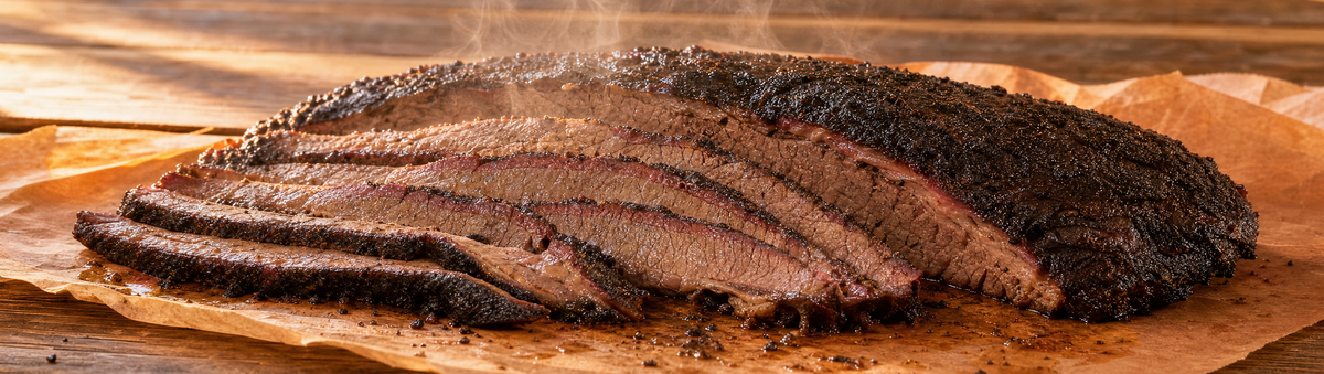 A competition-grade sliced brisket resting on a butcher-paper-lined board