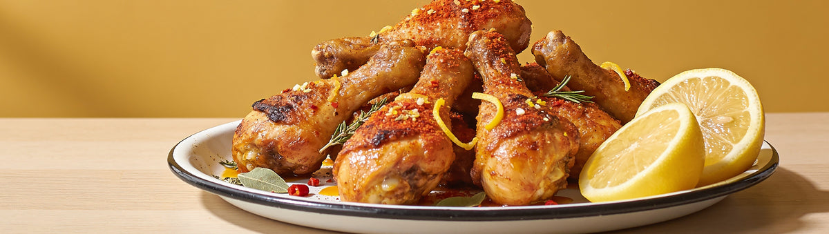 Ember Republic Leopard chicken rub with golden citrus-crusted chicken drumsticks and halved lemons
