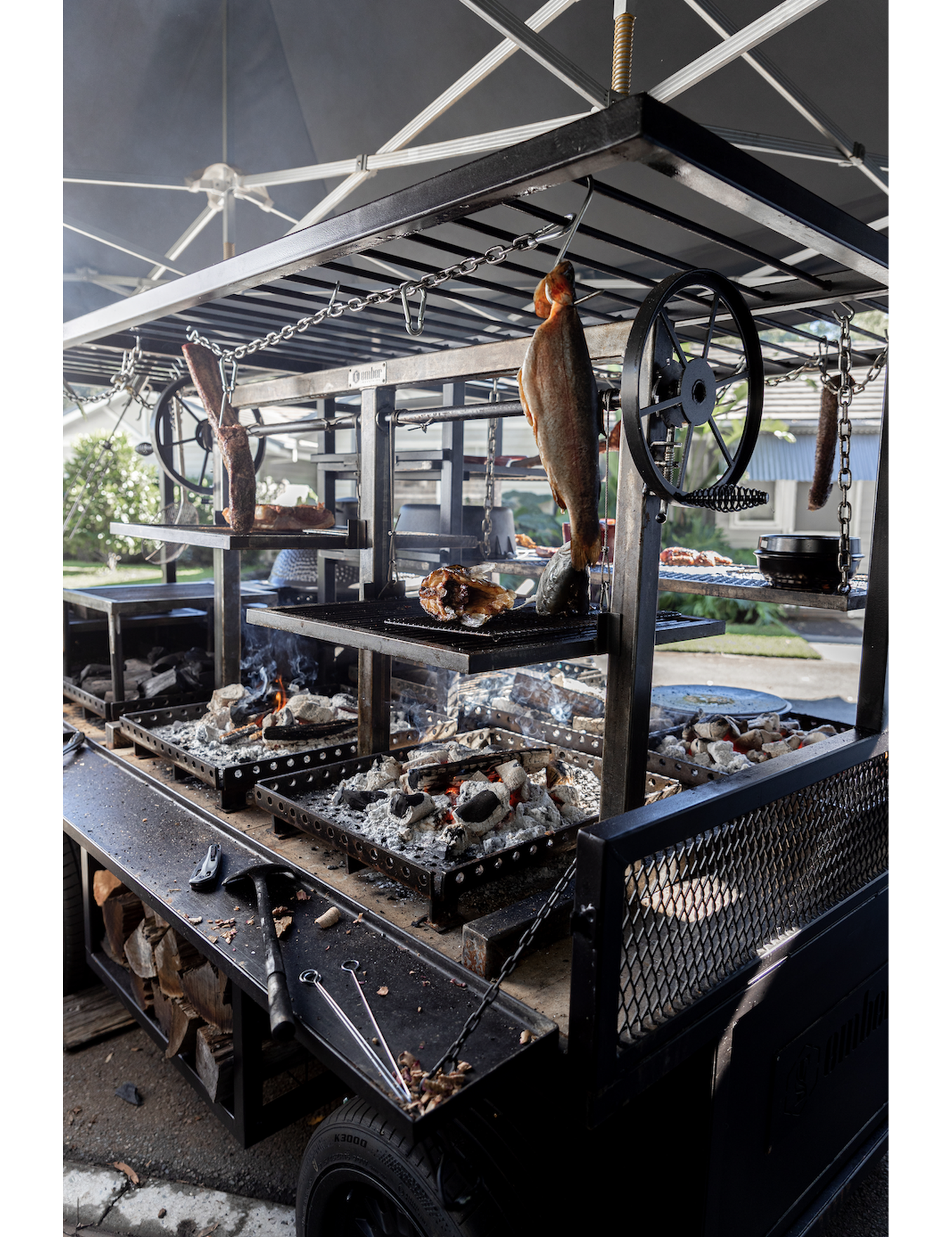 Fire Kitchen by Adam Roberts hardback cookbook — open-fire cooking rig with a whole fish hanging