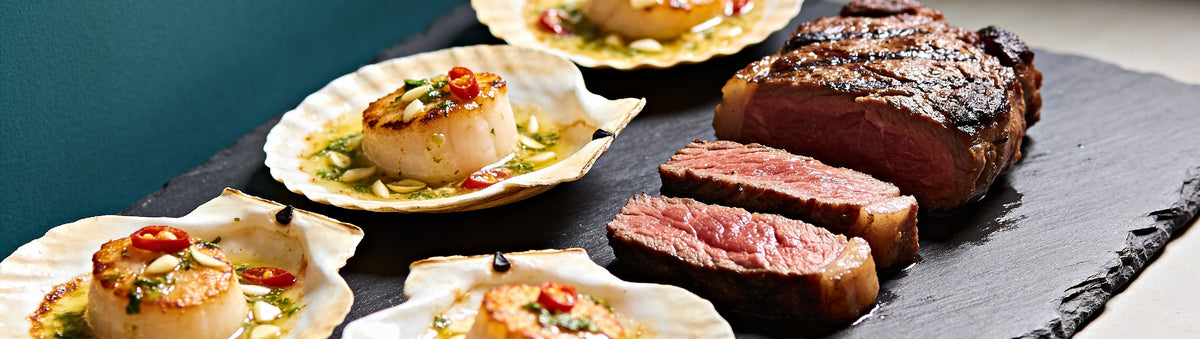 Fire Kitchen cookbook cover with flames, glowing coals, scallops in the shell and sliced steak