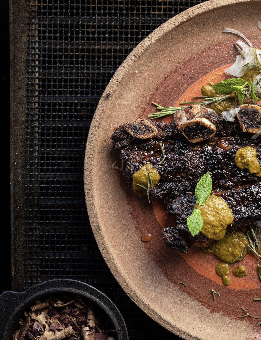 Fire Kitchen by Adam Roberts hardback cookbook — sliced steak with green sauce on a plate over the grill