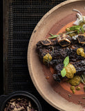 Fire Kitchen by Adam Roberts hardback cookbook — sliced steak with green sauce on a plate over the grill
