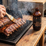 Four Saucemen The BBQ Sauce - pork ribs mopped with glossy barbecue sauce on the grill