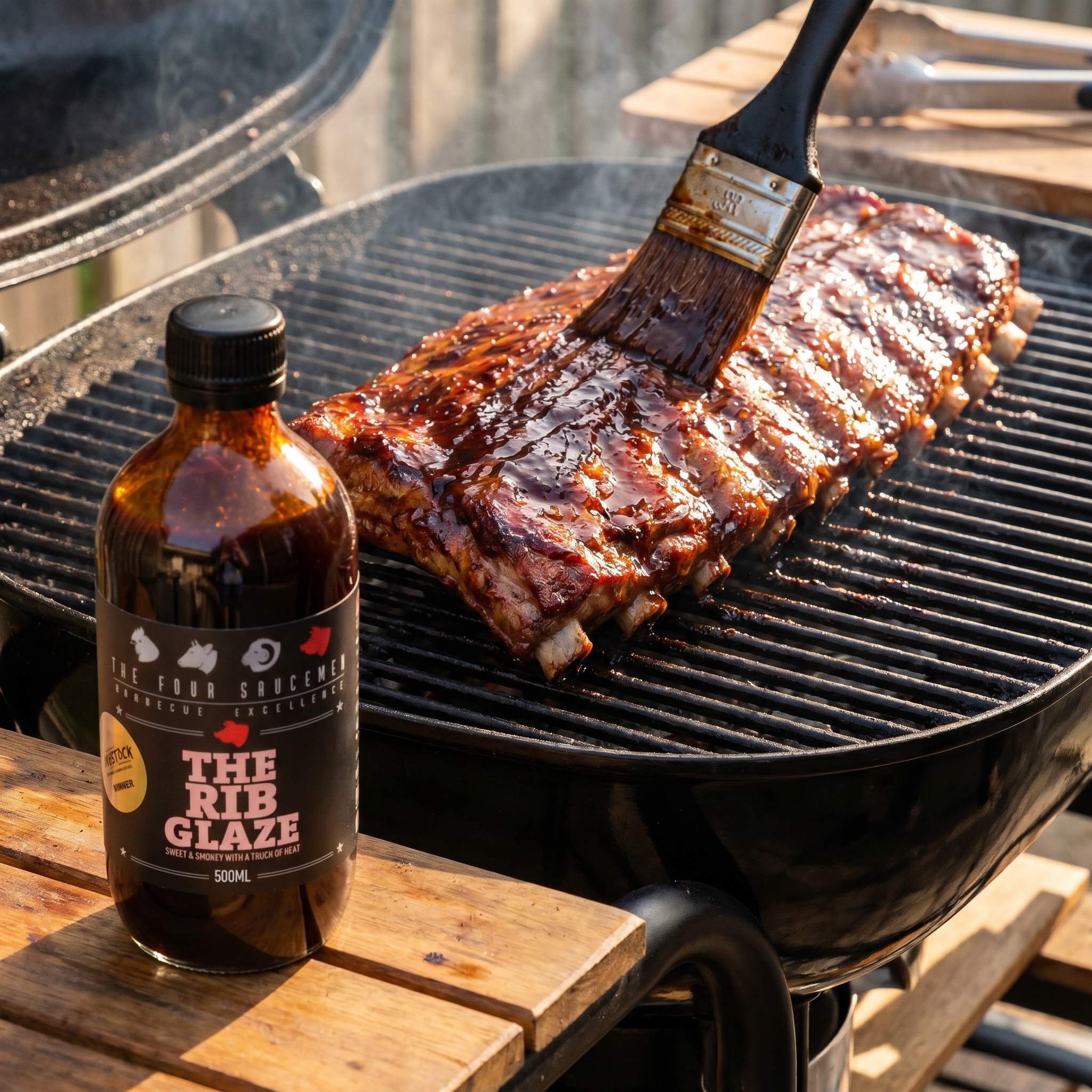 Four Saucemen The Rib Glaze - pork ribs being brushed with glossy glaze on the grill