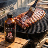 Four Saucemen The Rib Glaze - pork ribs being brushed with glossy glaze on the grill