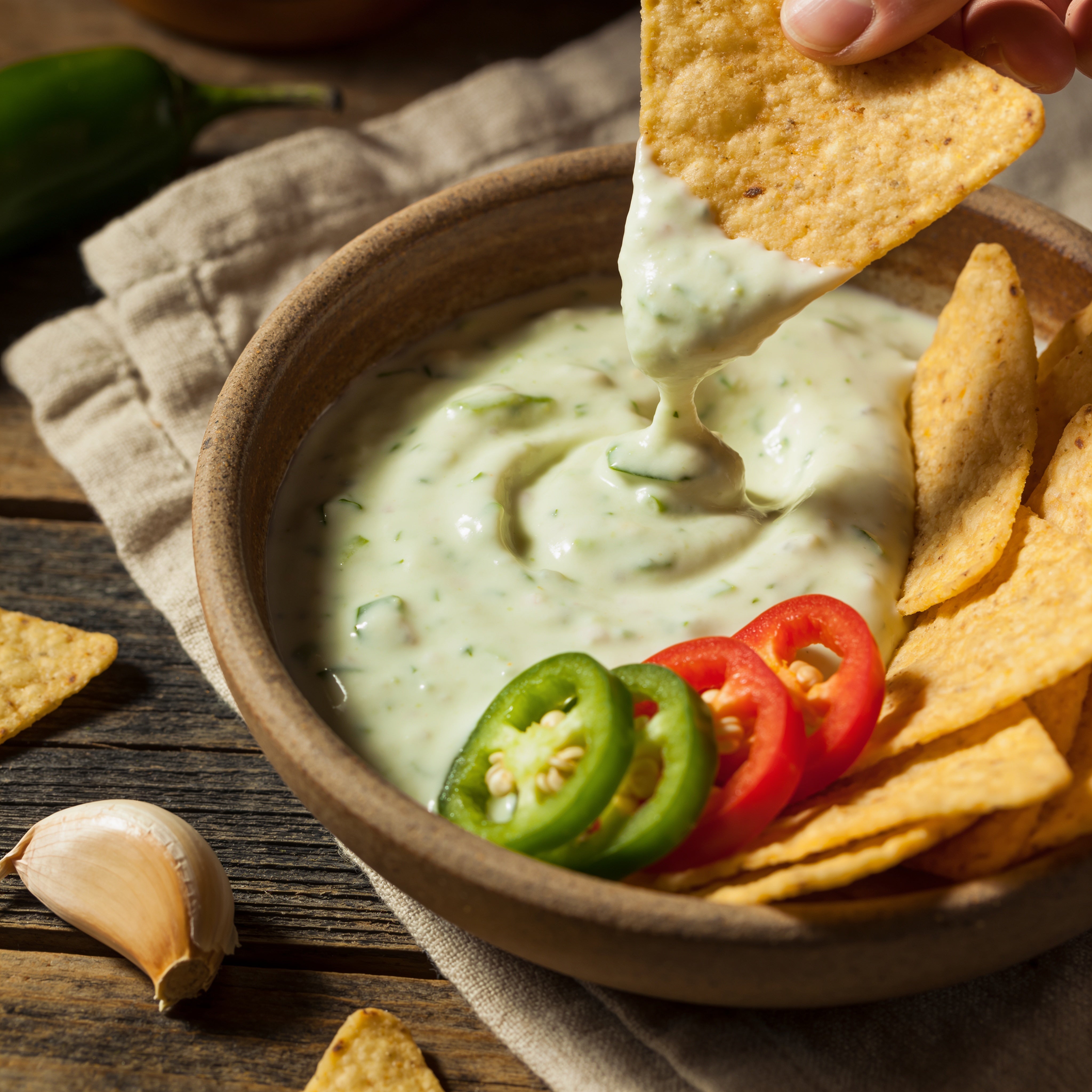 Smokes Seasoning Garlic Jalapeño Ranch used as a dip with tortilla chips, fresh jalapeno and garlic